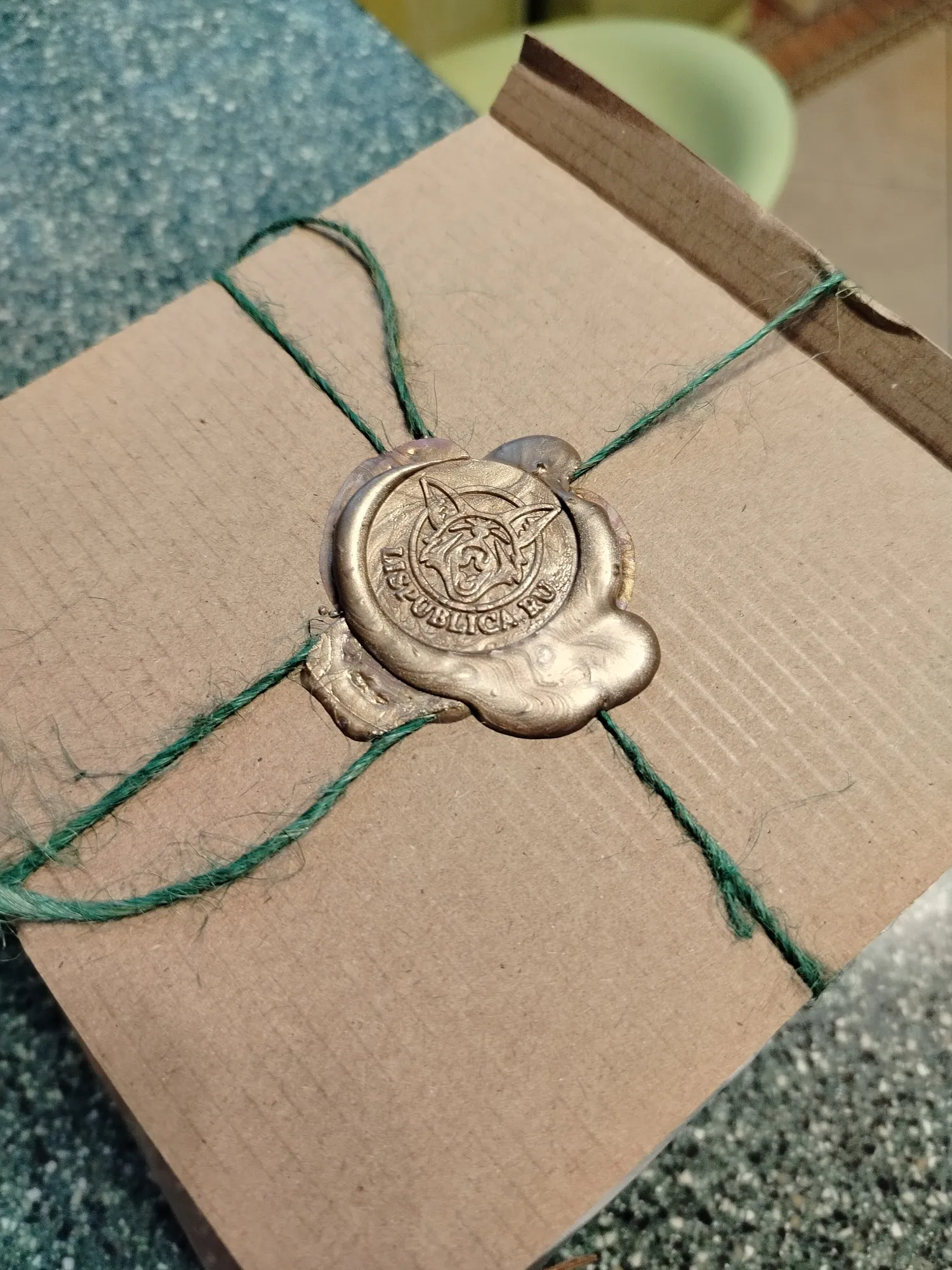 Внутри дополнительная упаковка в виде картонок сшитых нитками и закреплённых вот такой вот чудесной печатью. Даже вскрывать жалко было