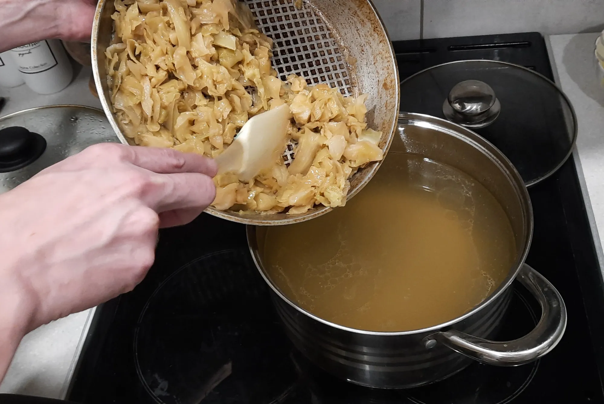 Отправляем в бульон тушёную капусту. Включаем самый слабый огонь. Пусть пока просто греется