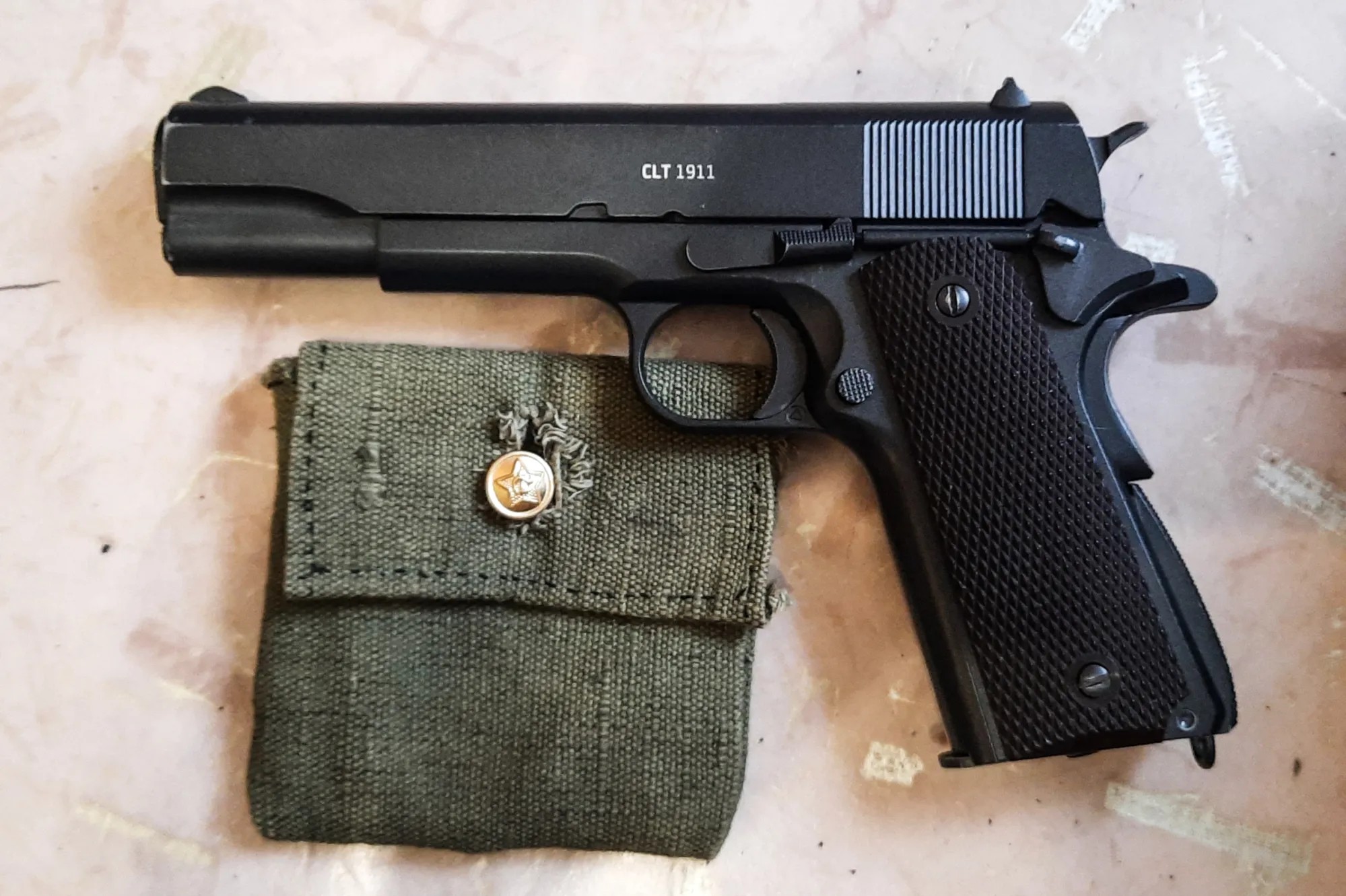 Кольт. Не боевой, конечно. Пневматика. Коллекционная модель, по весу и материалам такой же как настоящий, и разбирается полностью как оригинал, и даже отдачу даёт при выстреле. А при разрядке затвор уходит в заднее положение. Его я покупал уже в студенческие годы. До сих пор летом иногда хожу по бутылкам пострелять.