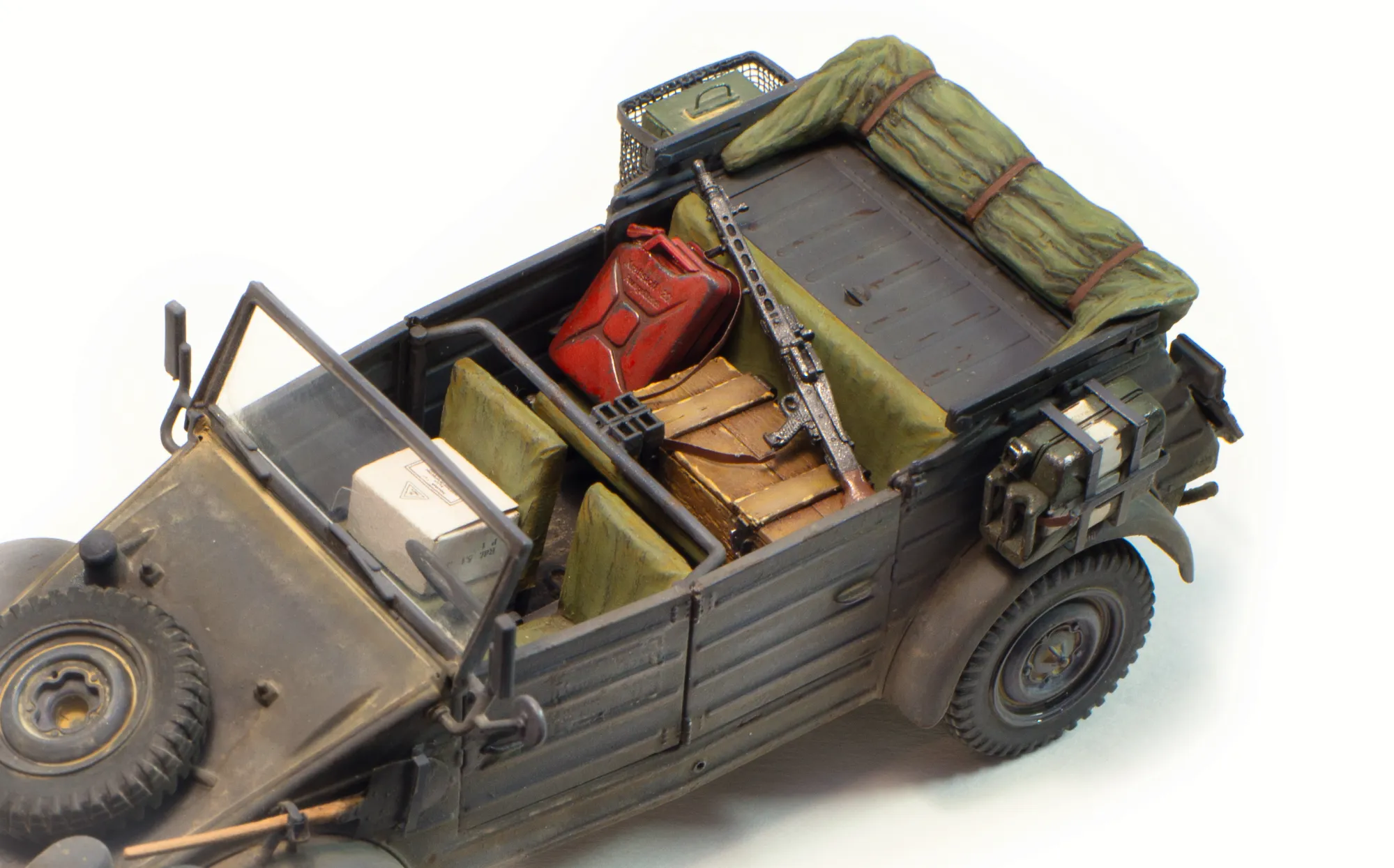 Сидения и скатка тента окрашены темперными красками, выполнена "смывка" жидко разведённой маслянной краской. В "салон" добавил отсебятины: коробку с тушёнкой (бумажный афтермаркет) , самодельный деревянный ящик, канистру бензина красного цвета (она прям хорошо получилась у меня) и пулемёт MG-42&nbsp; - модель оружия из другого набора.