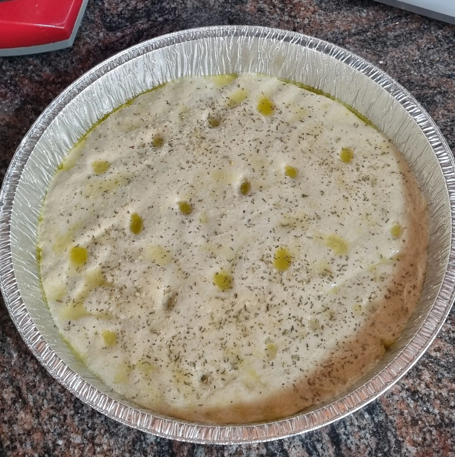 Натыкали в нём пальцами ямок, смазали оливковым маслом пополам с водой, посыпали морской солью с розмарином (у меня мельница со смесью, в оригинале солили крупной солью и целиковыми розмариновыми иголочками)